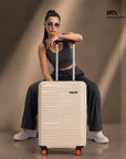 Beige small cabin suitcase front view with top handle and orange spinner wheels
