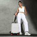 White small cabin suitcase with orange wheel caps and extended telescopic handle
