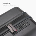 Hard-shell luggage close-up of TSA lock panel on dark polycarbonate shell.
