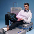 Silver polycarbonate trolley suitcase with extended handle and blue trim in use