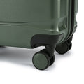 Green small cabin suitcase close-up of 360-degree wheel and corner base