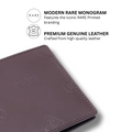 Dark brown leather bi-fold wallet close-up, embossed emblem and stitched corner edge